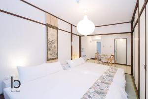 een slaapkamer met 2 witte bedden en een tafel bij Dai3Himawari - Stylish Apt 3mins walk PeacePark 4ppl in Hiroshima