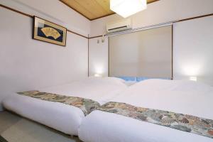 two white beds in a room with a window at Dai3Himawari - Stylish Apt 3mins walk PeacePark 4ppl in Hiroshima