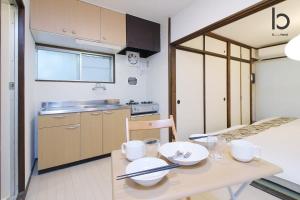 een kleine keuken met een houten tafel met borden erop bij Dai3Himawari - Stylish Apt 3mins walk PeacePark 4ppl in Hiroshima