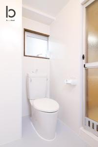 een witte badkamer met een toilet en een raam bij Dai3Himawari - Stylish Apt 3mins walk PeacePark 4ppl in Hiroshima
