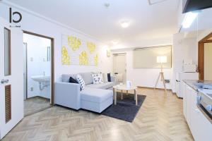 een woonkamer met een bank en een tafel bij Dai3Himawari by b hotel - Japanese Apt 3mins walk PeacePark 6ppl in Hiroshima