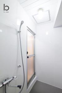 een douche in de badkamer met een spiegel bij bHOTEL Dai3Himawari - Japanese Apt 3mins walk PeacePark 6ppl in Hiroshima