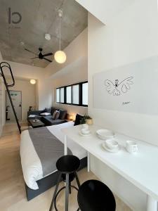 een slaapkamer met een bed en een tafel met stoelen bij bHOTEL Nekoyard - Brand new 1BR Apt for 7 ppl with loft Few Mins Walk To Peace Park in Hiroshima