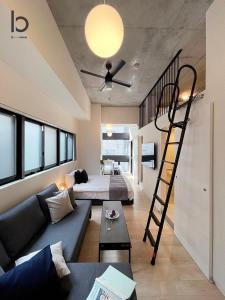 a living room with a couch and a spiral staircase at b hotel Nekoyard - Stylish Loft Studio Steps from Peace Park in Hiroshima +36 photos