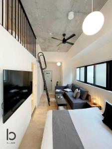 een woonkamer met een bed en een bank bij bHOTEL Nekoyard - Brand new 1BR Apt for 7 ppl with loft Few Mins Walk To Peace Park in Hiroshima