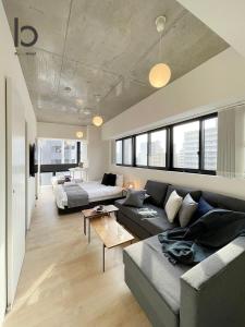 sala de estar con sofá y cama en bHOTEL Nekoyard - New Modern Beautiful 1 BR Apartment, Very Near Peace Park, for 6Ppl, en Hiroshima