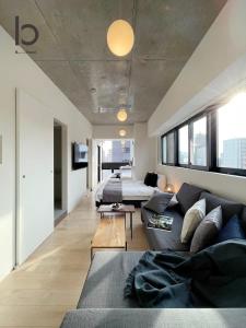 a living room with a couch and a bed at bHOTEL Nekoyard - New Modern Beautiful 1 BR Apartment, Very Near Peace Park, for 6Ppl in Hiroshima