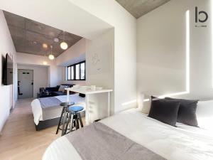 een slaapkamer met 2 bedden en een bureau. bij bHOTEL Nekoyard - Cozy 1BR Apartment, Very Near Peace Park, For 6 Ppl in Hiroshima