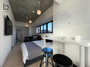 une chambre avec un lit et une table avec un bar dans l'établissement b hotel Nekoyard - Cozy Studio Near Peace Park & City Center, à Hiroshima