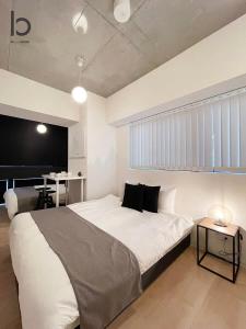 - une chambre avec un grand lit blanc et un bureau dans l'établissement bHOTEL Nekoyard - 1BR Apartment, Good for 6 Ppl, Near Peace Park, WIFI Available, à Hiroshima