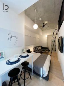 広島市にあるbHOTEL Nekoyard - 1 Bedroom with Loft Good For 7PPL Close To Peace Parkのベッドルーム1室(ベッド1台、テーブル、スツール2脚付)