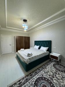 a bedroom with a large bed and a rug at City Plaza Krenkel 2 in Samarkand