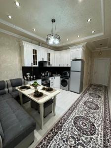 a kitchen and living room with a couch and a table at City Plaza Krenkel 2 in Samarkand