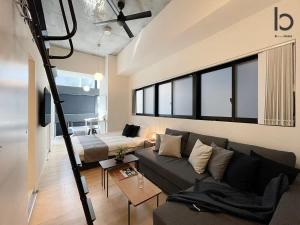 a living room with a couch and a bed at bHOTEL Nekoyard - Modern new 1BR apt very close to peace park room wifi 7ppl in Hiroshima