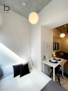 a bedroom with a white bed and a desk at bHOTEL Nekoyard - Modern new 1BR apt very close to peace park room wifi 7ppl in Hiroshima