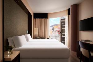 a hotel room with a large bed and a window at NH Tenerife in Santa Cruz de Tenerife