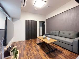 uma sala de estar com um sofá e uma mesa de centro em bHOTEL Casaen - Brand New 1BR Apt Near Hondori Shopping District For 6 Ppl em Hiroshima