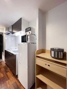 a kitchen with a white refrigerator and a microwave at bHOTEL Casaen - Brand New 1BR Apt Near Hondori Shopping District For 6 Ppl in Hiroshima