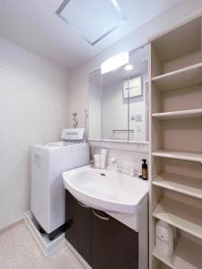 a bathroom with a sink and a washer and dryer at bHOTEL Casaen - Brand New 1BR Apt Near Hondori Shopping District For 6 Ppl in Hiroshima