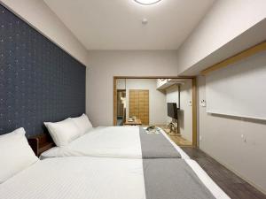 ein Schlafzimmer mit einem großen weißen Bett in einem Zimmer in der Unterkunft bHOTEL Casaen - 1BR Apartment with beautiful City View Near Shopping District For 6Ppl in Hiroshima