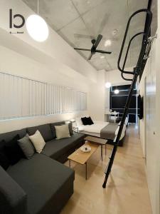 a living room with a couch and a ladder at b hotel Nekoyard - Loft Studio 5 Min Walk to Peace Park in Hiroshima