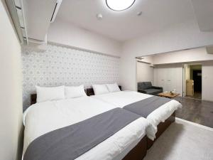 um quarto com uma cama grande e uma sala de estar em bHOTEL Casaen - Spacious 1BR Apt For 6 Ppl Great Location with room wifi em Hiroshima