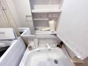 a bathroom with a white sink in a room at bHOTEL Casaen - Cozy 1BR Apt near Hondori District for 6 Ppl in Hiroshima