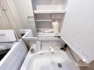 uma casa de banho com um lavatório branco num quarto em bHOTEL Casaen - Spacious 1BR Apt For 6 Ppl Great Location with room wifi em Hiroshima