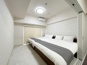 a bedroom with a large bed in a room at Casaen by b hotel - Entire Apt for 6Ppl City Center in Hiroshima
