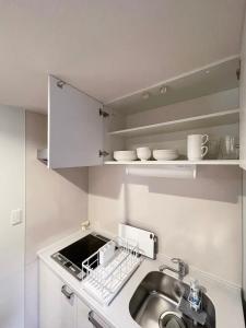 a small kitchen with a sink and a counter top at Casaen by b hotel - Entire Apt for 6Ppl City Center in Hiroshima