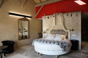 Schlafzimmer mit einem Bett und einem Spiegel in der Unterkunft Hôtel-Spa Le Saint Cirq in Tour-de-Faure
