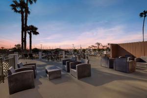 a patio with chairs and tables and palm trees at Comfort Inn San Diego Airport At The Harbor in San Diego