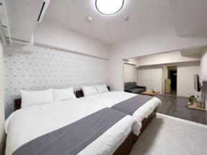 Un dormitorio con una cama grande y una sala de estar en Casaen by b hotel- Modern 1 BR near Hondori District for 6 Ppl, en Hiroshima 27 fotos más