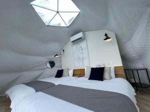 een slaapkamer met 2 bedden en een dakraam bij bLOCAL Sugawa House - 2 BR Beach Front House for 8 Ppl in Kure