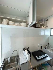 eine Küche mit einer Spüle und einer Theke mit Geschirr in der Unterkunft bLOCAL Sugawa House - 2 BR Beach Front House for 8 Ppl in Kure
