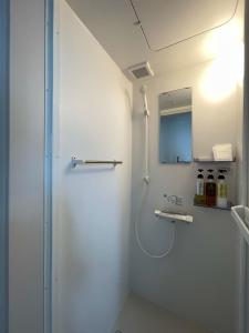 y baño con cabina de ducha y espejo. en bLOCAL Sugawa House - 2 BR Beach Front House for 8 Ppl en Kure