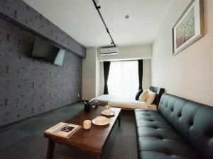 a living room with a couch and a table at bHOTEL Nagomi - Beautiful 1 BR New Apt City Center for 3 Ppl in Hiroshima