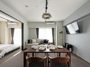 a room with a table and chairs and a bed at bHOTEL Nagomi - Beautiful 2BR Apt City Center for 10 Ppl in Hiroshima