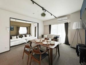 a living room with a table and a bed at bHOTEL Nagomi - Large 2BR Apt City Center for 10 Ppl in Ōsukachō
