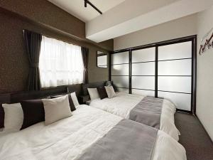 Postel nebo postele na pokoji v ubytování bHOTEL Nagomi - Large 2BR Apt City Center for 10 Ppl