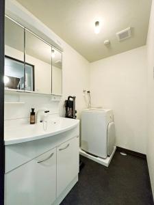 a white bathroom with a sink and a refrigerator at bHOTEL Nagomi - Large 2BR Apt City Center for 10 Ppl in Ōsukachō