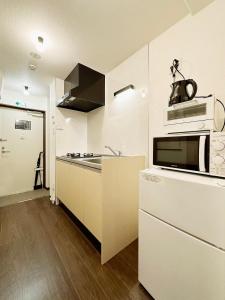 广岛Nagomi by b hotel - Comfy Apartment for 3 people near City Center的厨房里有水槽和微波炉