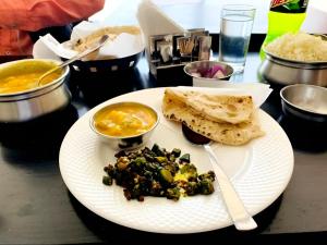 un piatto bianco con cibo su un tavolo di The NDVL Hotel - Top Rated and Most Awarded Property in Haridwar a Haridwār