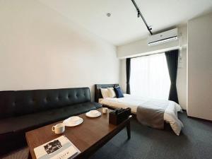 Pokój z łóżkiem, kanapą i stołem w obiekcie bHOTEL Nagomi - Comfy 1 Bedroom in City Center for 3ppl w mieście Hiroszima