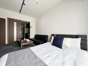 広島市にあるbHOTEL Nagomi - Comfy 1 Bedroom in City Center for 3pplのベッドルーム(大型ベッド1台、ソファ付)