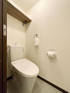 a bathroom with a toilet and a roll of toilet paper at bHOTEL Nagomi - Comfy 1 Bedroom in City Center for 3ppl in Hiroshima