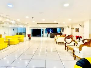un vestíbulo de un hotel con mesas y sillas amarillas en The NDVL Hotel - Top Rated and Most Awarded Property in Haridwar en Haridwār