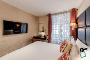 una camera d'albergo con letto e finestra di Hotiday Collection Paris - Arc de Triomphe a Parigi