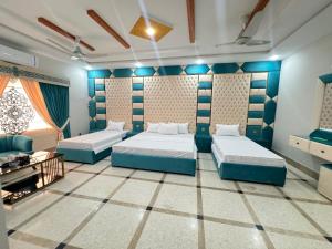 um quarto com 2 camas e um sofá em Royal Executive Inn Guest House em Islamabad