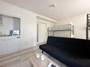 尾道市bHOTEL Yutori - 1Br Apt with Balcony for 4 Ppl in Onomichi的带沙发和双层床的客厅